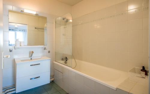 une salle de bain avec une baignoire et un lavabo et une baignoire tubermottermott dans l'établissement Le City, à Rodez