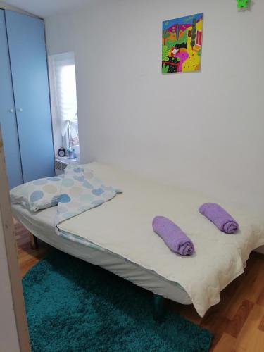 Una cama en una habitación con almohadas moradas. en Small low cost Dorcol, en Belgrado