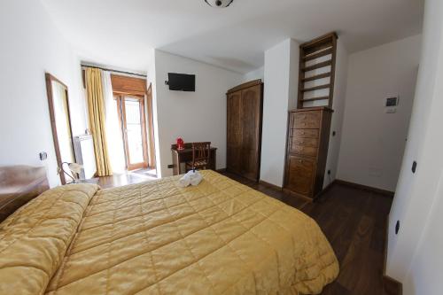 a bedroom with a large bed and a wooden dresser at River Hotel in Castel di Sangro