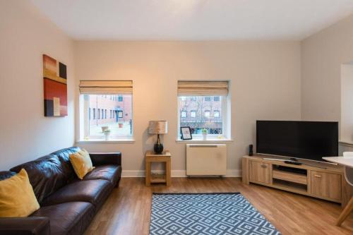 a living room with a couch and a flat screen tv at The Maltings in Edinburgh