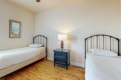 a bedroom with two beds and a lamp on a night stand at Beach Retreat in Galveston