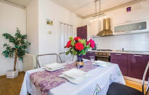 une cuisine avec une table et un vase de fleurs. dans l'établissement Apartment Ana, à Rijeka