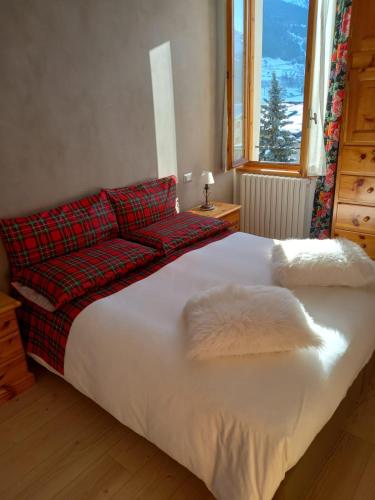 a bed with a red couch in a bedroom at Appartamenti Via Monte Braulio 19 in Bormio