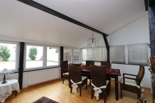 a dining room with a table and chairs and windows at Ferienhaus DaVinci in Zell an der Mosel