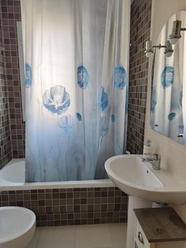 a bathroom with a shower curtain and a sink at Carnaval 16 in Isla Cristina