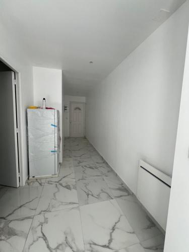 Cette chambre blanche dispose d'un couloir avec un réfrigérateur. dans l'établissement Victor 2, à Avesnes-sur-Helpe