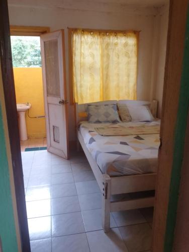 a small bedroom with a bed and a window at Mary's Homestay Apo island in Dumaguete