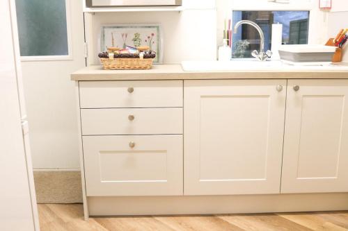 a kitchen counter with white cabinets and a sink at Sunrise, 3 east view in Bamford