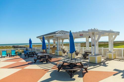 a group of picnic tables and umbrellas on the beach at Beach Retreat in Galveston