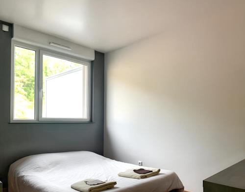a bedroom with a bed with two towels on it at Appartement confortable à Apach avec balcon in Apach