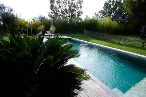 - une piscine dans une cour avec une terrasse en bois dans l'établissement Appartement dans petit mas calme, à Valergues