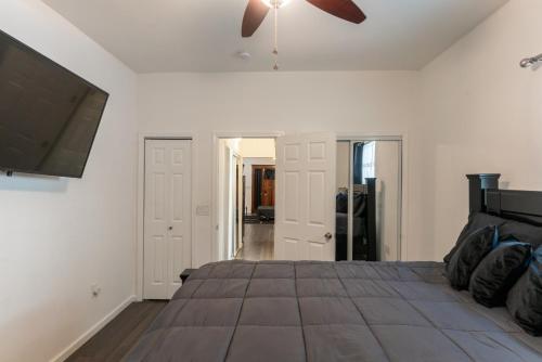 a bedroom with a large bed with a ceiling fan at Beautiful Home With Jazucci Tub in New Orleans