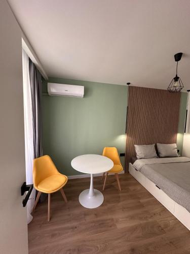a bedroom with a bed and a table and chairs at Piata Unirii Apartment in Cluj-Napoca