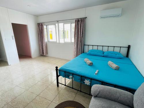 a bedroom with a blue bed and a couch at Studio Opuhi in Papeete