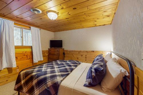 a bedroom with a bed in a room with wooden ceilings at Dani’s Trailside Escape in Manitowish Waters