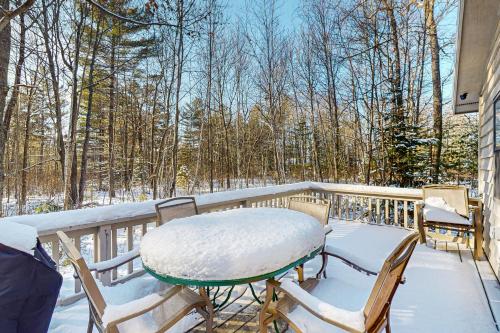 a table and chairs on a balcony with snow on it at Dani’s Trailside Escape in Manitowish Waters