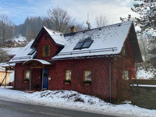 a red house with snow on top of it at Chalupa u Žalských in Benecko