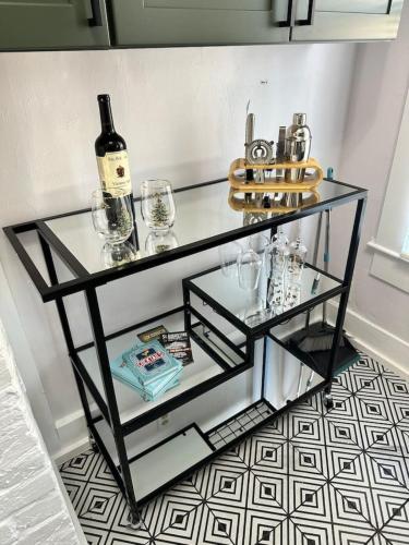 a glass table with a bottle of wine and glasses at Cedar Street Retreat A Central Downtown in Saint Augustine