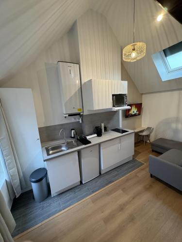a kitchen with white cabinets and a sink at Mezza Summer 3ème Étage in Abbeville