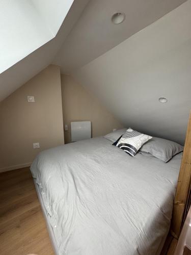 a bedroom with a white bed in a attic at Mezza Summer 3ème Étage in Abbeville