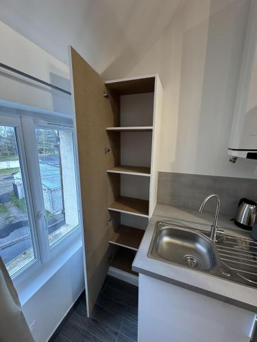 a small kitchen with a sink and a window at Mezza Summer 3ème Étage in Abbeville