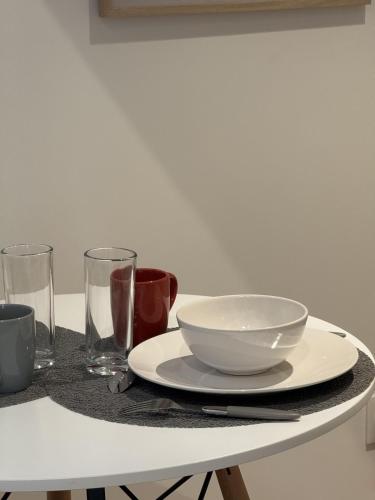 a table with a white bowl and glasses on it at Mezza Summer 3ème Étage in Abbeville