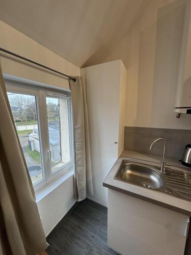 a small kitchen with a sink and a window at Mezza Summer 3ème Étage in Abbeville