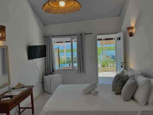 a bedroom with a large white bed and a desk at Restaurante & Pousada Gaivota in Santo André