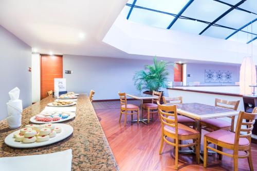 ein Esszimmer mit Tischen und Stühlen und eine Küche in der Unterkunft Doubletree By Hilton Bogota Calle 100,Co in Bogotá