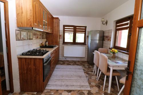 a kitchen with a table and a stove top oven at GreenMoodHouse in Comăneşti