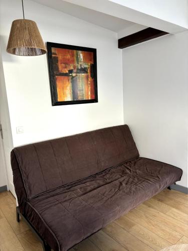 a brown couch in a room with a painting at Pavillon indépendant au 1er étage de deux chambres in Le Blanc-Mesnil