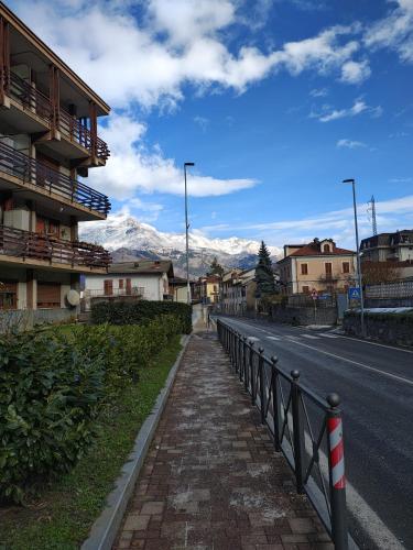a street with a fence and a road with mountains at The Valley Escape in Chiomonte