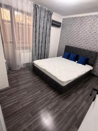 a bedroom with a large bed with blue pillows at Ama Residence in Brăila