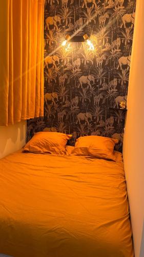 - une chambre dotée d'un lit avec des draps orange et du papier peint dans l'établissement Le Pixie II modern studio easy airport access, à Toulouse