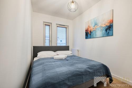 a bedroom with a bed with a blue blanket at Diasfera Premium by LookAp in Łódź