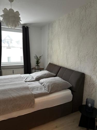 a bed in a bedroom with a large window at Interior Apartments - Service Apartments in Bahnhofsnähe und UNESCO-Bergpark mit Parkplatzmöglichkeit, EBK, kinderfreundlich, Familienzimmer in Kassel