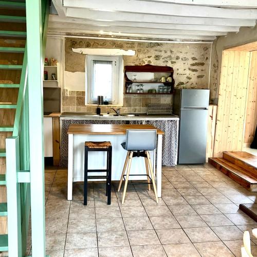 - une cuisine avec un comptoir, 2 chaises et un réfrigérateur dans l'établissement Charmante gîte met prachtig uitzicht, à La Cellette