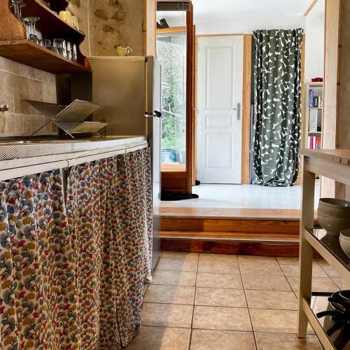 une cuisine avec un réfrigérateur et une porte menant à une chambre. dans l'établissement Charmante gîte met prachtig uitzicht, à La Cellette