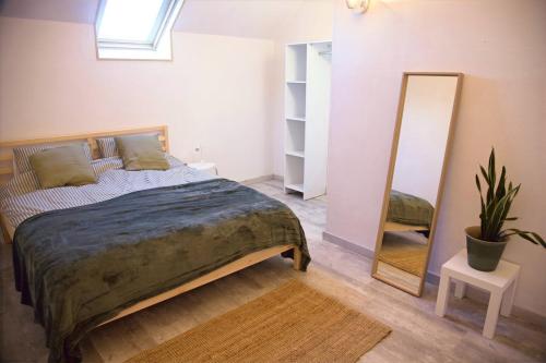 une chambre avec un grand lit et un miroir dans l'établissement Charmante gîte met prachtig uitzicht, à La Cellette