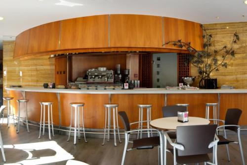 a kitchen with a bar with chairs and tables at Hotel Vetusta in Oviedo