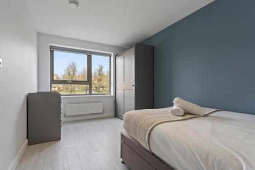 a bedroom with a large bed and a window at Exquisite 7 Bedroom 5 Bathroom House - Over 1900 sqft - Close to City Centre with Free Parking, Fast W-Fi and SmartTVs by Yoko Property in Northampton