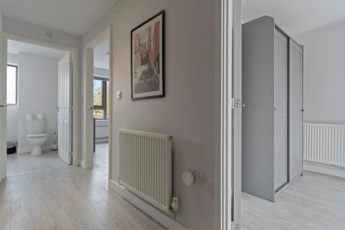 a white room with a toilet and a mirror at Exquisite 7 Bedroom 5 Bathroom House - Over 1900 sqft - Close to City Centre with Free Parking, Fast W-Fi and SmartTVs by Yoko Property in Northampton