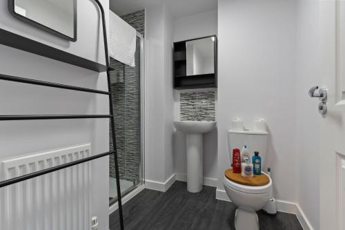 a white bathroom with a toilet and a sink at Exquisite 7 Bedroom 5 Bathroom House - Over 1900 sqft - Close to City Centre with Free Parking, Fast W-Fi and SmartTVs by Yoko Property in Northampton