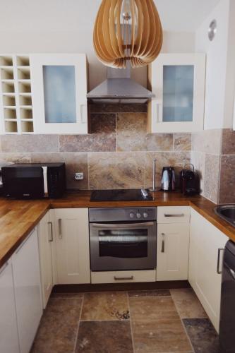 une cuisine avec une cuisinière et un micro-ondes dans l'établissement Appartement Courchevel la Tania, à Courchevel