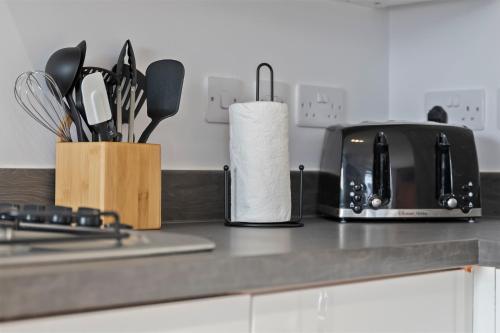 a kitchen counter with a toaster and a roll of paper towels at Exquisite 7 Bedroom 5 Bathroom House - Over 1900 sqft - Close to City Centre with Free Parking, Fast W-Fi and SmartTVs by Yoko Property in Northampton