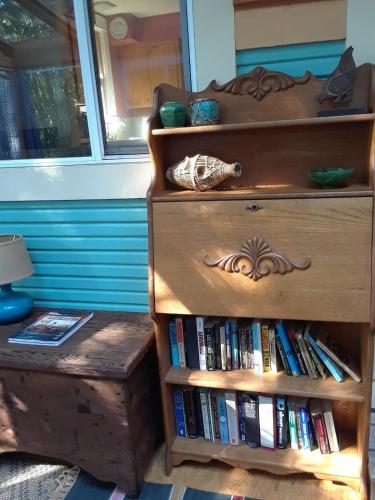 a wooden dresser with a book shelf filled with books at Bohemian Bamboo Hideaway in Portland