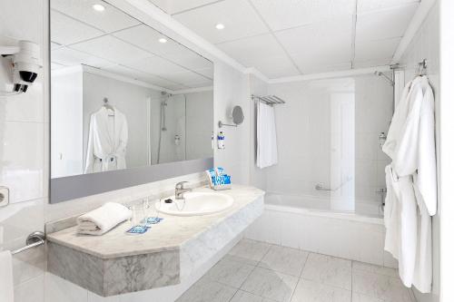 a white bathroom with a sink and a bath tub at Sol Arona Tenerife in Los Cristianos