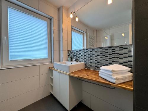un baño con lavabo y espejo en See Raum, en Immenstaad am Bodensee