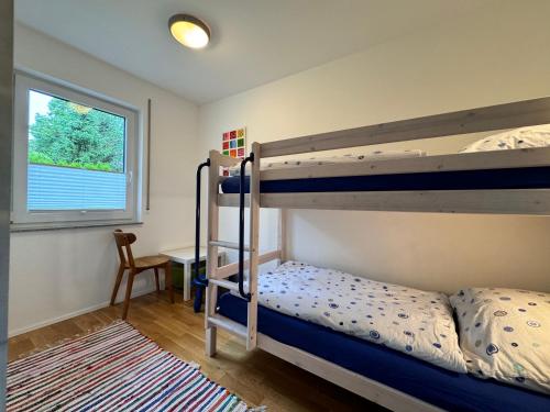 Un dormitorio con dos literas y un escritorio. en See Raum, en Immenstaad am Bodensee