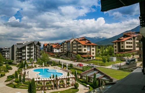 a resort with a swimming pool and some buildings at Cozy apartmen with Mountain view in Bansko
